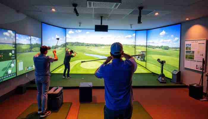 Indoor golf simulator showcasing a realistic driving range and golf course graphics, with players enjoying the game in a cozy environment.