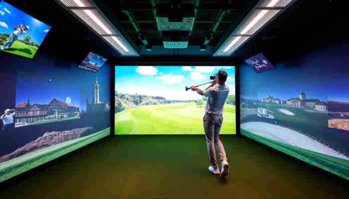 Golfer swinging in a high-tech indoor golf simulator with tracking sensors and a virtual course display