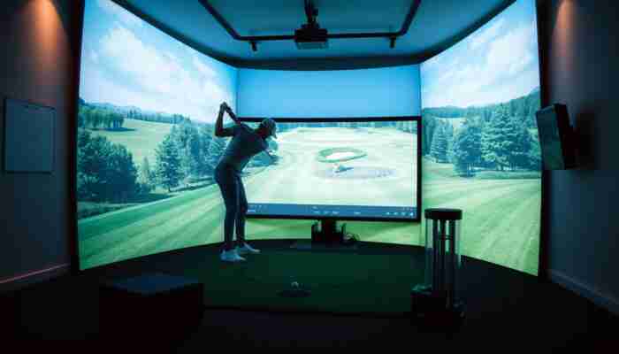 Golfer using an indoor golf simulator for swing analysis with launch monitor data and virtual ball flight